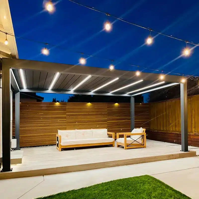 A backyard louvered pergola at night