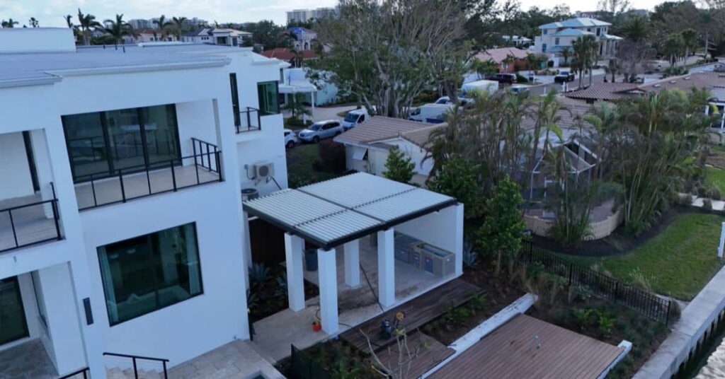 Aerial view of an aluminum wind resistant pergola installed beside a modern home